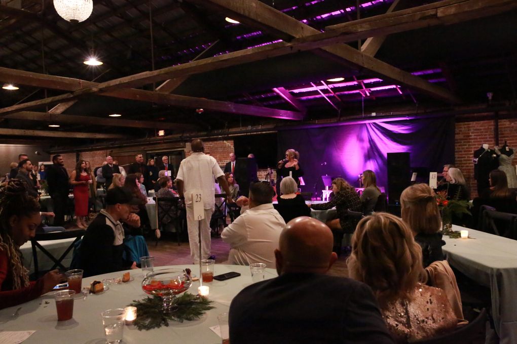 Guests at a social event under purple stage lights